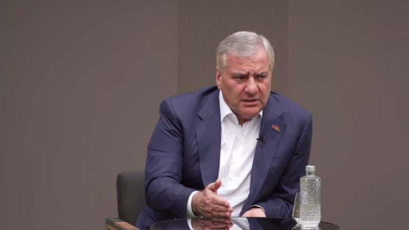 Самвел Карапетян, лидер партии Сильная Армения, на фоне партийной символики